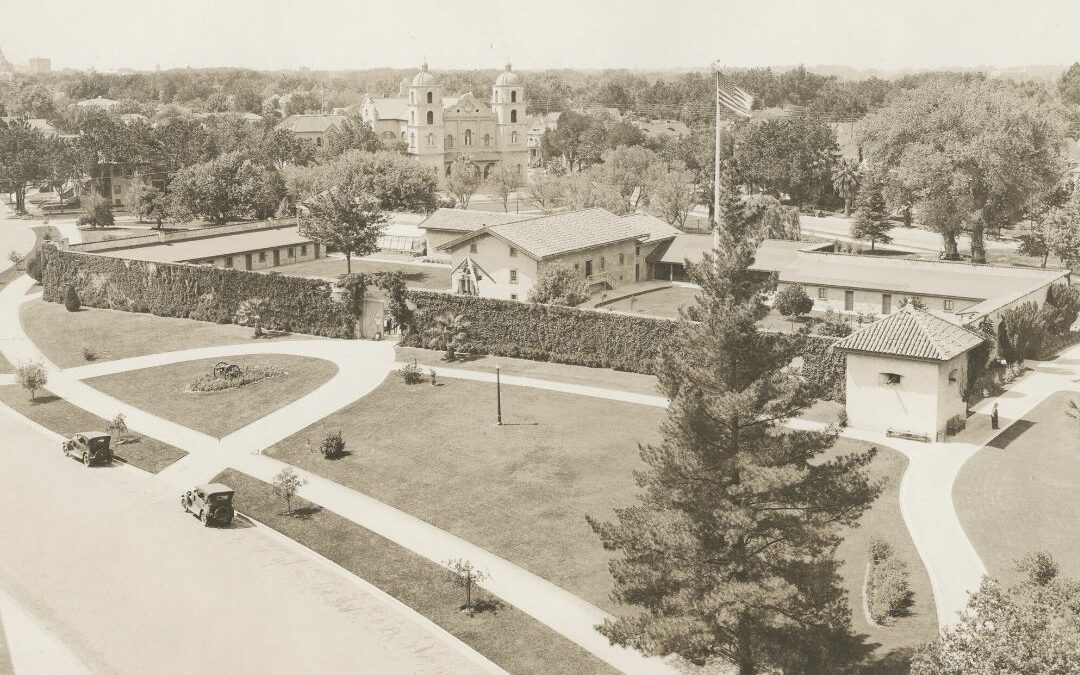 This undated postcard gives an elevated view of Sutter's Fort. Notice St. Francis Church in background and tree lined skyline. A very tall flag pole rises in the middle of the Fort.