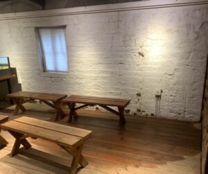 A wet wood floor inside an adobe brick room