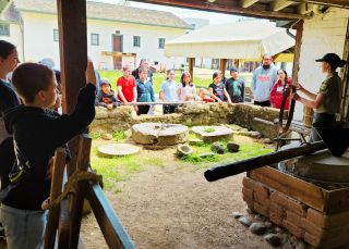 students gather around the grist mill at Sutter's Fort.