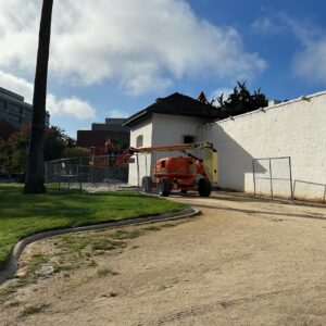 Outside of Sutter's Fort construction crews erect a fence with a heavy duty lift. 