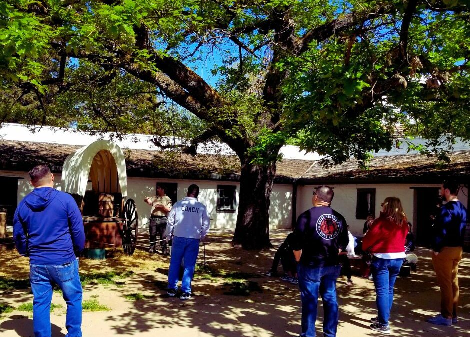 Visitors gather under the Oak Tree. A covered wagon stands in front of them.
